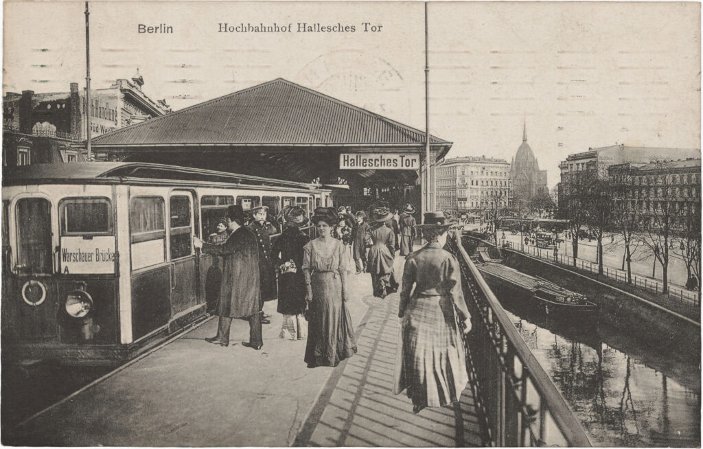 Bildkomposition u. feine weiße Ränder um die abgebildeten Personen u. Gegenstände verweisen auf die Montage des Motives. Hochbahnhof Hallesches Tor, o.D. (verschickt 1910), SPP / FHXB 1643